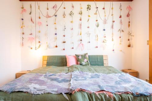 a bedroom with a bed with a bunch of decorations on the wall at 古民家再生ホテル　Relink in Fujiyoshida