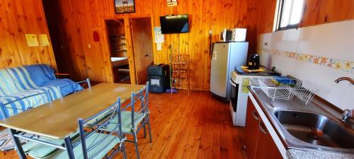 a kitchen with a table and a sink and a refrigerator at Hostal La Maravilla in Vilches