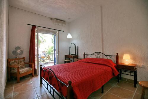 a bedroom with a bed with a red blanket at 9 Musses Hotel Apartments in Skala Mistegnon