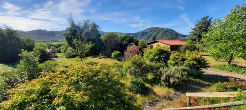 a garden with a house and mountains in the background at Hostal La Maravilla in Vilches