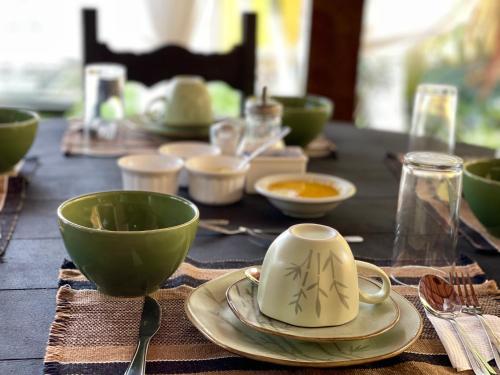a wooden table with bowls and cups on it at Pousada Areias do Pero in Cabo Frio