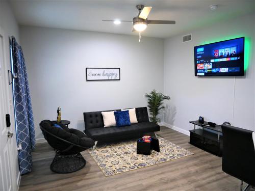 sala de estar con sofá y TV de pantalla plana en Rare Vibrant Hidden Gem - 2 Mins from Downtown, en Dallas