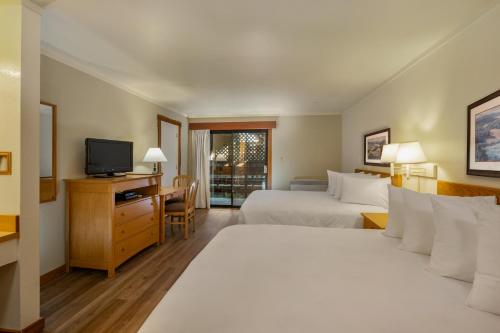 a hotel room with two beds and a television at Harbor Lite Lodge in Fort Bragg