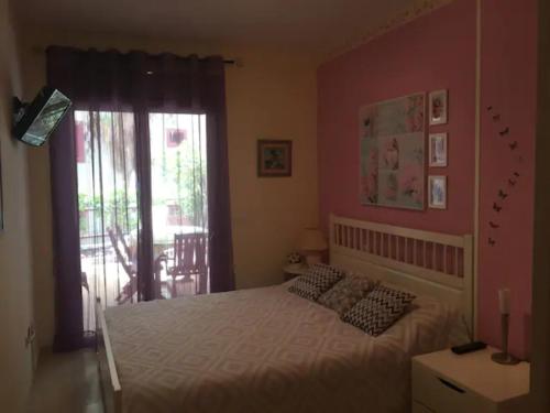 a bedroom with a bed with white sheets and a window at Lovely family apartment in high quality residence in Palm-mar