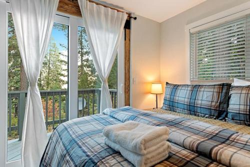 a bedroom with a bed and a balcony with windows at Starfall in Yosemite West