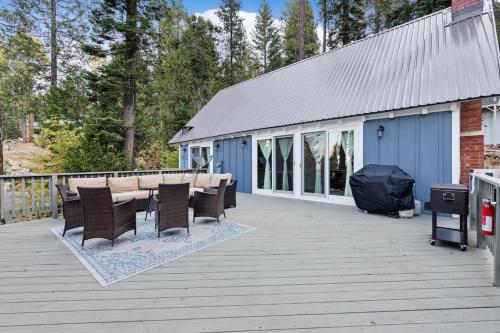 a deck with a table and chairs and a building at Starfall in Yosemite West
