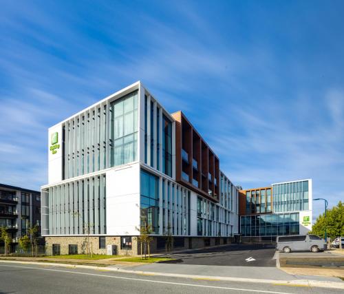 an office building with glass windows on a street at Holiday Inn Queenstown Remarkables Park in Queenstown