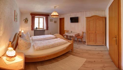 a bedroom with a large bed and a table with a table at Hörlhof - Chiemgau Karte in Inzell