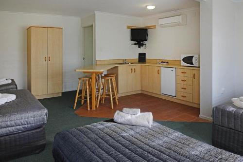 Habitación con cocina con cama y mesa. en Warwick Vines Motel, en Warwick