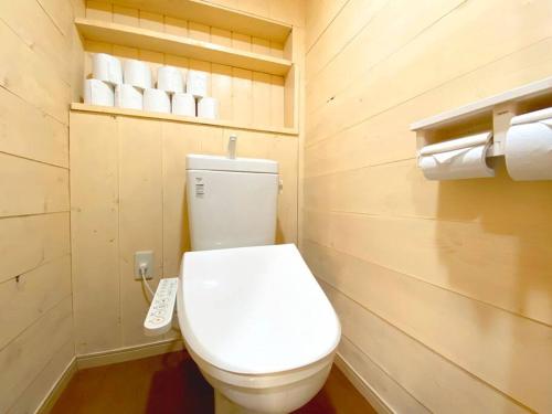 a bathroom with a white toilet and rolls of toilet paper at Fukoji in Kawaba