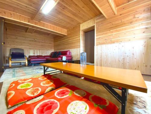 a wooden room with a table and a couch at Fukoji in Kawaba