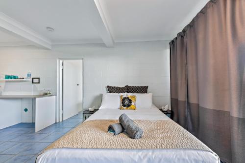 a bedroom with a large bed with two pillows on it at Airlie Sun & Sand Accommodation #2 in Airlie Beach