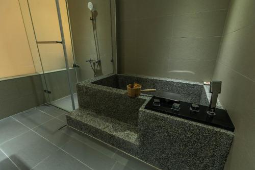 a bathroom with a bath tub with a shower at Yesday B&B in Dongshan