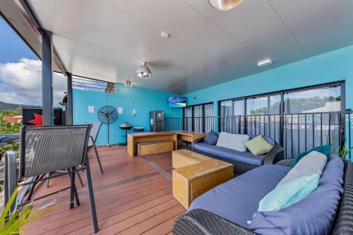 a living room with a couch and a tv on a balcony at Airlie Sun & Sand Accommodation #2 in Airlie Beach