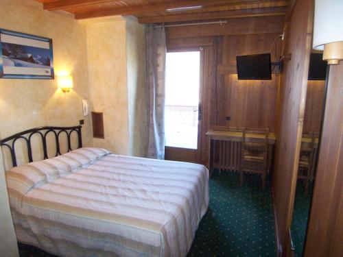 une chambre d'hôtel avec un lit et une télévision dans l'établissement Hôtel Les Bernards, à Praz-sur-Arly