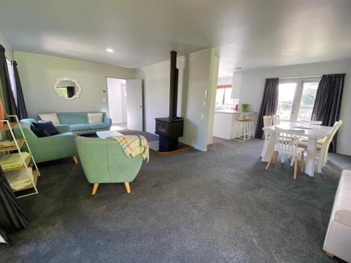 a living room with a couch and a stove at Motuoapa Bay Chalets in Turangi