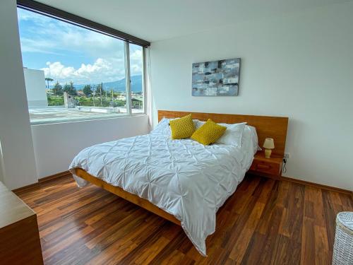 En eller flere senge i et værelse på HERMOSO DEPARTAMENTO CON INCREIBLES VISTAS CUMBAYA