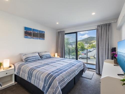 Un dormitorio con una cama y una puerta corrediza de vidrio. en Dolphin Cove 8, 2-6 Government Rd - Air conditioning, Wi-Fi, lift, secure parking and close to town, en Nelson Bay