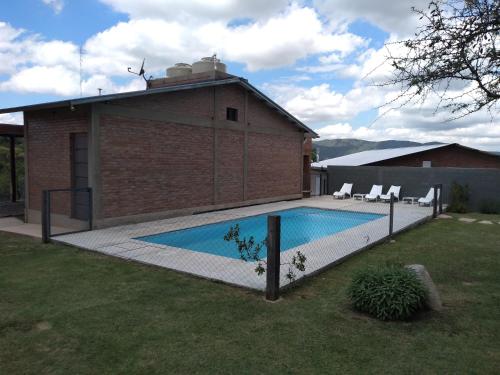 聖羅莎德克蘭穆齊塔的住宿－Cabañas Quimera，一座房子旁的院子内的游泳池
