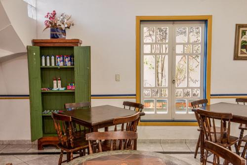 a dining room with a table and chairs and a window at Pousada da Tina in Ubatuba