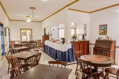 a restaurant with tables and chairs and a counter at Pousada da Tina in Ubatuba