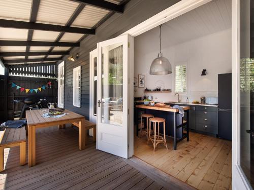 a kitchen and dining room with a table and a door at The Elm Tree in Daylesford