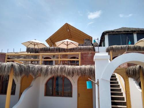 a house with a thatched roof with a staircase on it at Hamacas in Punta Negra