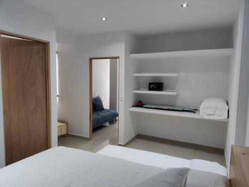 a bedroom with a bed and a mirror and a chair at Azul departamento 34 m2 Nuevo in Jiutepec