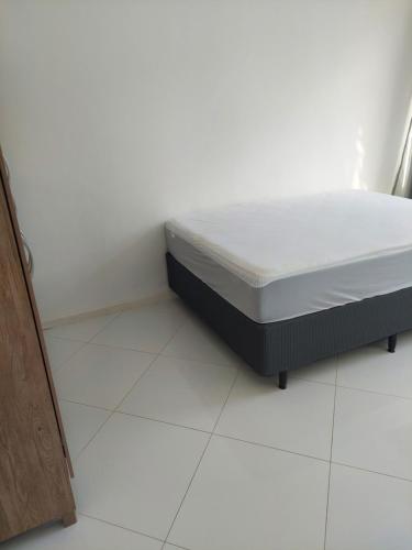 een bed op een witte vloer in een kamer bij Salvador porto da barra in Salvador