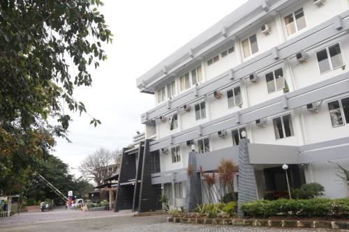 a large white building on a street at Plum Hotel Lading Banda Aceh in Banda Aceh