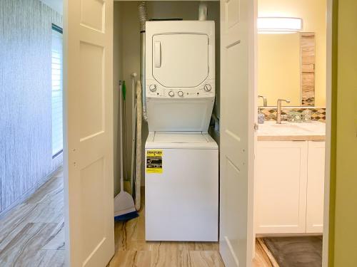 a washer and dryer sitting on top of a refrigerator at Waiohuli Beach Hale D227 - Aloha La'i - Oceanfront/1b1b/Wifi/AC/Cable/Pool/Extras in Kihei