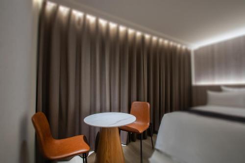a hotel room with a bed and a table and chairs at 168 Motel-Zhongli in Zhongli
