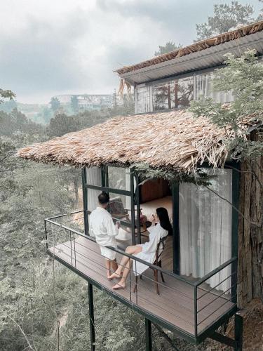a couple sitting on a balcony of a house at Chillout Village - Homestay Tam Đảo in Vĩnh Phúc