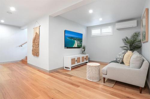 a living room with a couch and a table at Luxe Coastal Abode, Marcus Beach in Marcus Beach