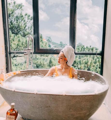 a woman in a bath tub in a window at Chillout Village - Homestay Tam Đảo in Vĩnh Phúc