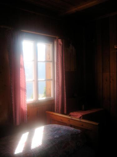 a bedroom with a window and a bed in a room at Almhütte Gorgasser in Heiligenblut
