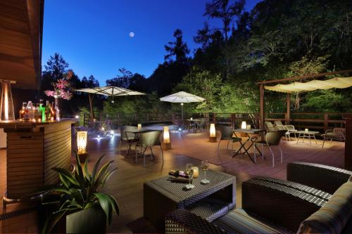a patio with tables and chairs and umbrellas at night at Hotel Ryu Resort and Spa in Takayama