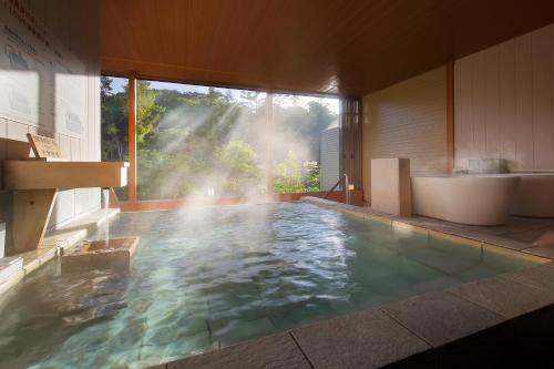 a bathroom with a tub and a bathtub and a sink at Hotel Ryu Resort and Spa in Takayama