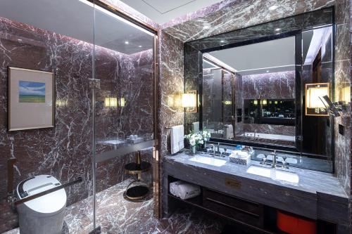 a bathroom with a sink and a mirror at Wyndham Grand Foshan Gaoming in Gaoming
