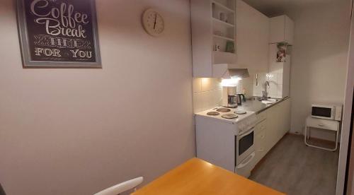 una piccola cucina con tavolo e piano cottura forno superiore di Ivalo Apartment a Ivalo
