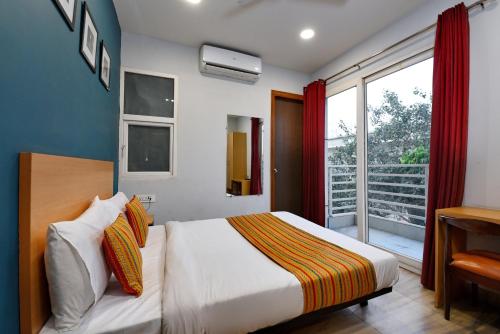 a bedroom with a bed and a large window at Hotel Silver Saffron Near Paschim Vihar Metro Station in New Delhi
