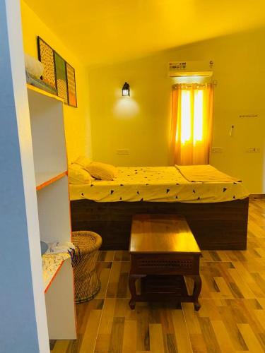 a room with two beds and a table in it at Bleu & Blanc in Puducherry