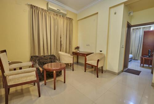 a living room with a couch and a table and chairs at Tea Pavilion in Bengaluru