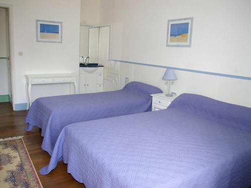 two beds in a hotel room with purple sheets at Gîte Chabris, 5 pièces, 11 personnes - FR-1-591-18 in Chabris