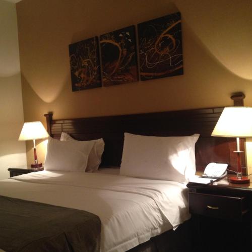 a bedroom with a large white bed with two lamps at Executives Hotel - Azizia in Riyadh