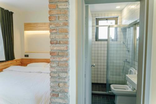 1 dormitorio con pared de ladrillo junto a la cama en FLANEUR HOSTEL en Antalya