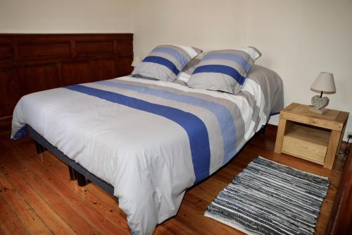 - un grand lit avec des draps bleus et blancs et une table dans l'établissement Appartement 4 personnes Mers Les Bains, à Mers-les-Bains