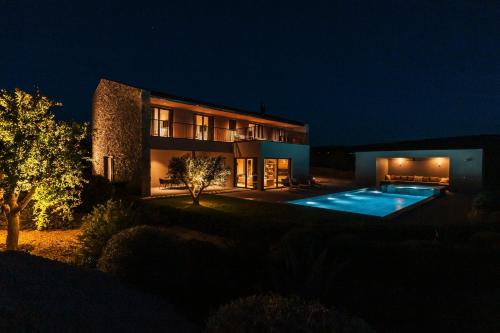 a house with a swimming pool at night at Villas Misto in Primošten