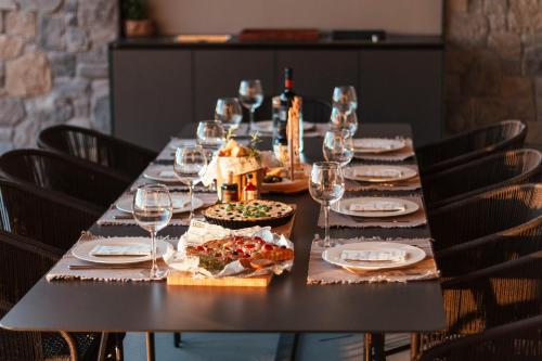 a long table with wine glasses and food on it at Villas Misto in Primošten