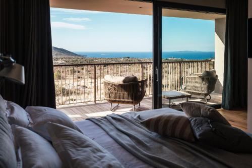 a bedroom with a bed and a view of the ocean at Villas Misto in Primošten